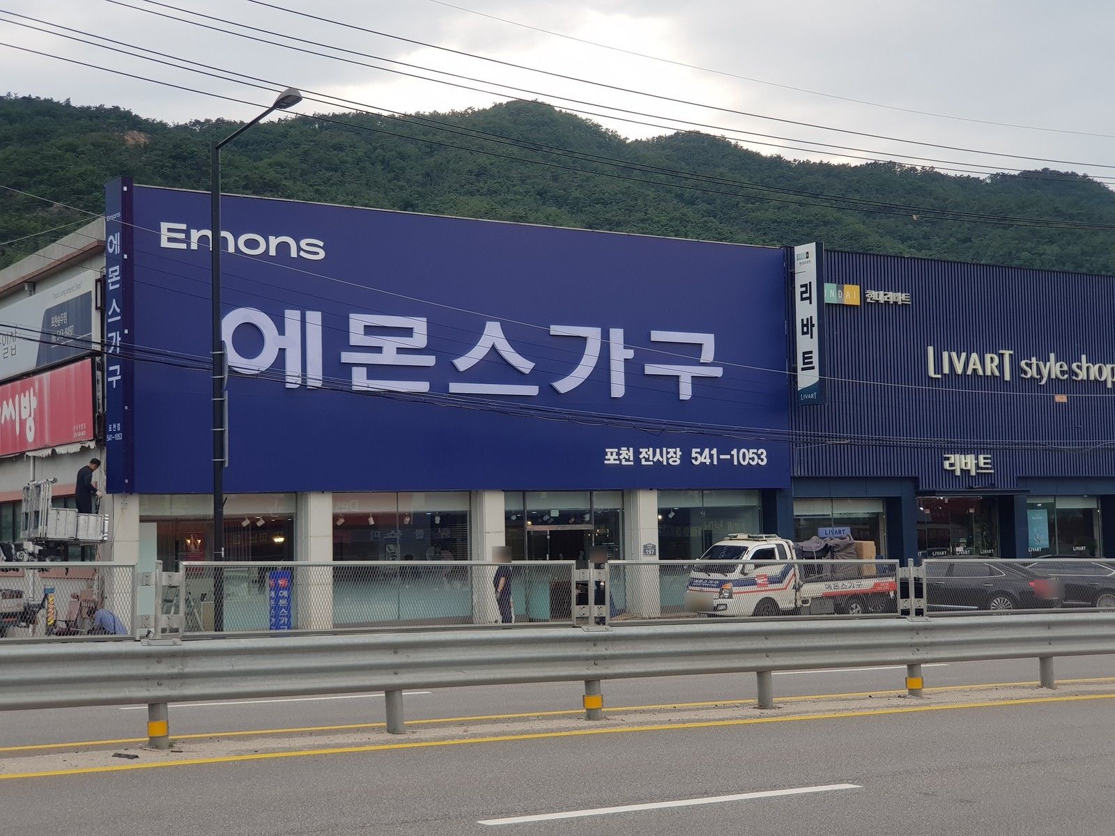 대형 가구 전시장 건물 상단을 덮은 파란색 에몬스가구 간판